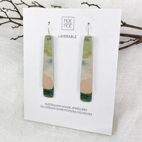 Pair of layered earrings on a Moe Moe branded card  background.