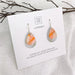 Teardrop-shaped earrings on a Moe Moe branded card 