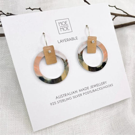 Pair of hoop earrings with wooden accents on a Moe Moe branded card.