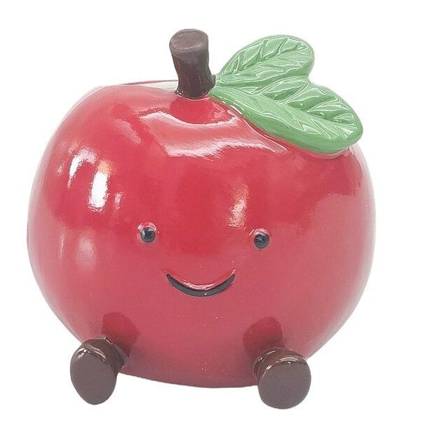 Red apple-shaped object with a face, wheels, and a leaf 