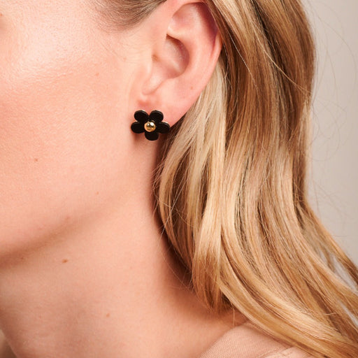 black floral earring with gold accents.