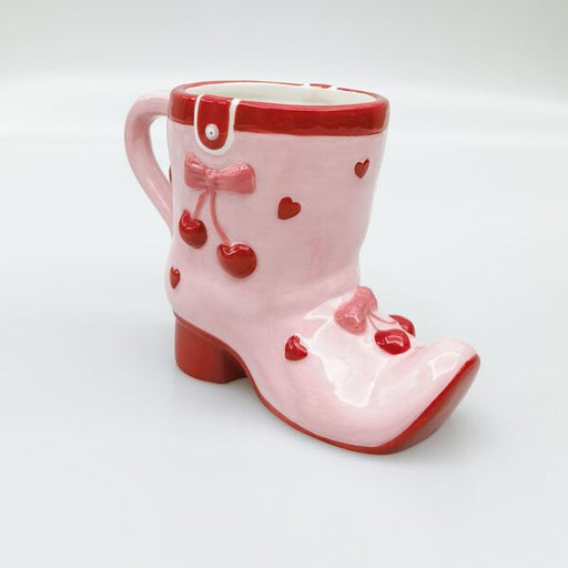Pink ceramic boot-shaped mug with red accents 