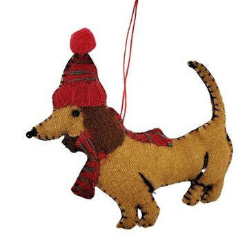 Decorative dachshund ornament wearing a red hat and scarf 