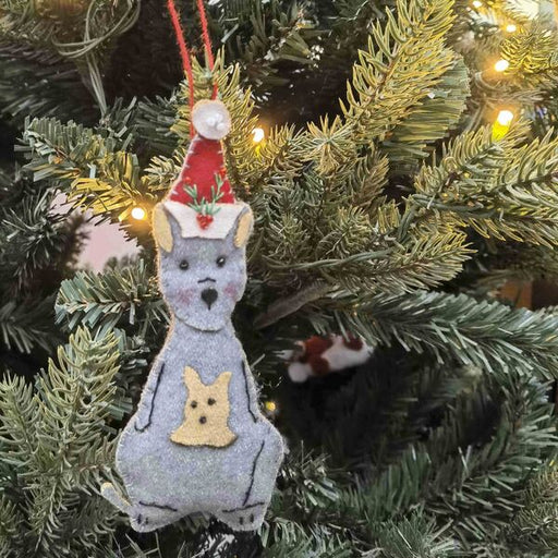 Decorative Christmas ornament of a kangaroo with a Santa hat on a Christmas tree.