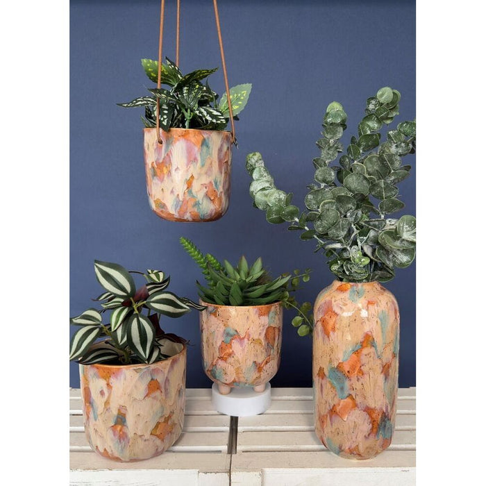 collectin of matching pink artistic planters and vases