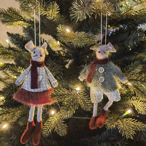 Two decorative mouse ornaments hanging on a Christmas tree.