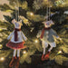Two decorative mouse ornaments hanging on a Christmas tree.