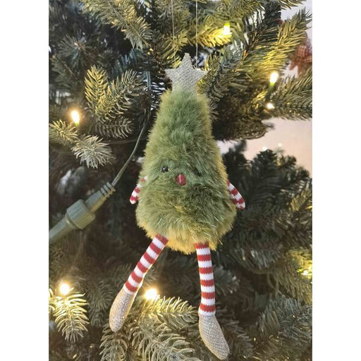 Fuzzy green Christmas tree ornament with striped legs hanging on a decorated tree.