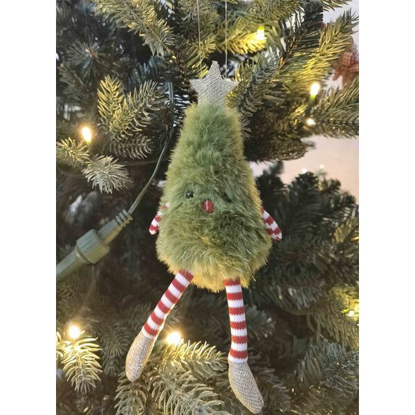 Fuzzy green Christmas tree ornament with striped legs hanging on a decorated tree.