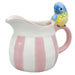 Ceramic pitcher with pink stripes and a bird figurine 