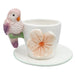 Ceramic cup and saucer with a decorative parrot figurine 