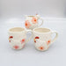Set of ceramic mugs and a pitcher with chicken and flower designs 
