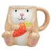 Ceramic mug shaped like a rabbit holding carrots   