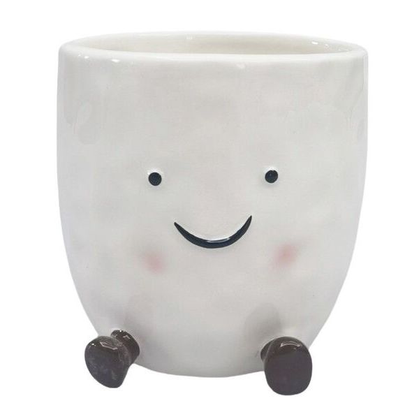 White ceramic planter with a smiling face and black legs 