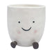 White ceramic planter with a smiling face and black legs 