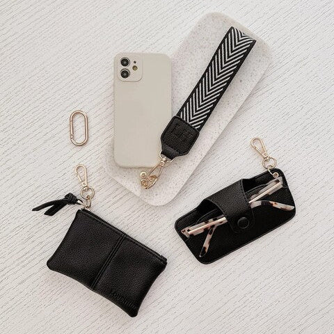 Collection of black accessories including a phone case, keychain, and pouch 