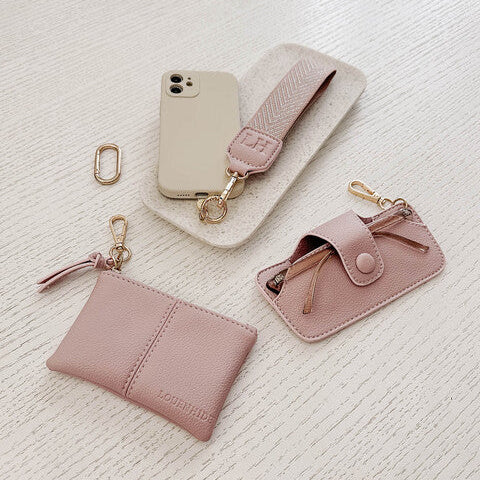 Set of pink leather accessories including a wallet, keychain, and glasses case 