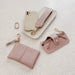 Set of pink leather accessories including a wallet, keychain, and glasses case 